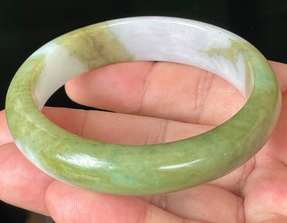 Close-up of fine crystalline texture and rich forest green tones on icy apple green jadeite bangle