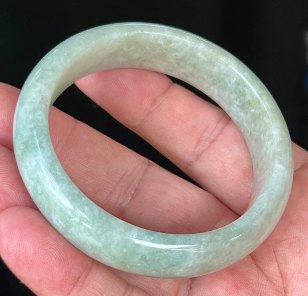 Close-up of fine crystalline texture and spicy apple green hues on milky white jadeite bangle