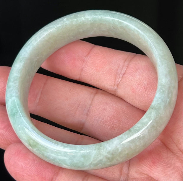 Close-up of fine crystalline texture and spicy apple green hues on milky white jadeite bangle