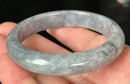 Close-up of fine crystalline texture and subtle honey hues on icy grey jadeite bangle