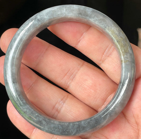 Close-up of fine crystalline texture and subtle honey hues on icy grey jadeite bangle
