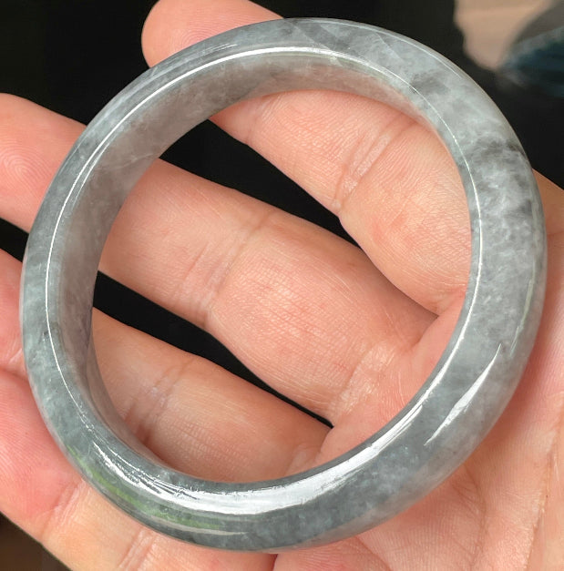 Close-up of fine crystalline texture and subtle honey hues on icy grey jadeite bangle