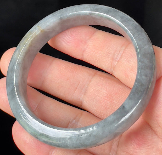 Close-up of fine crystalline texture and subtle honey hues on icy grey jadeite bangle