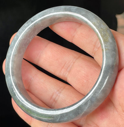 Close-up of fine crystalline texture and subtle honey hues on icy grey jadeite bangle
