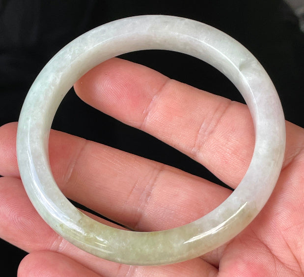 Close-up of fine crystalline texture and subtle natural jade veins on icy milky white jadeite bangle