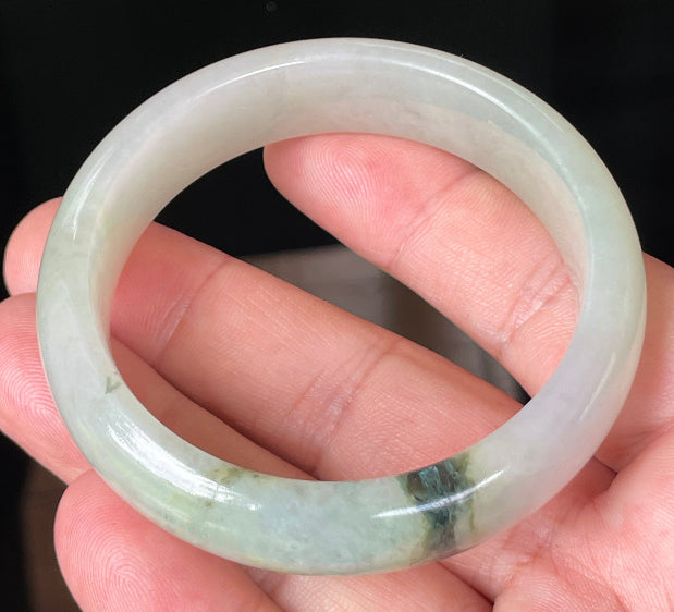 Close-up of fine crystalline texture and icy light apple green hues on jadeite bangle