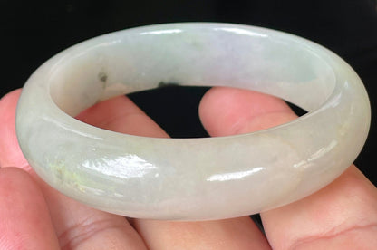 Close-up of fine crystalline texture and icy light apple green hues on jadeite bangle