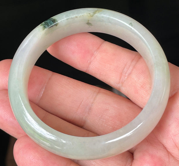 Close-up of fine crystalline texture and icy light apple green hues on jadeite bangle
