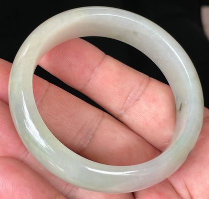 Close-up of fine crystalline texture and icy light apple green hues on jadeite bangle