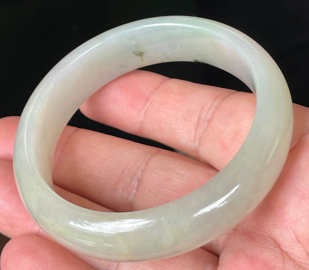 Close-up of fine crystalline texture and icy light apple green hues on jadeite bangle