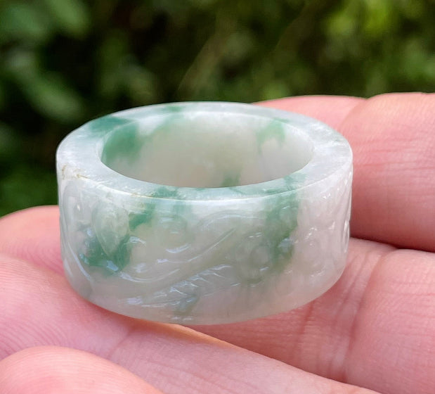 Close-up of continuous flowing swirl patterns and fine-grained texture on an icy imperial green Burmese jade ring