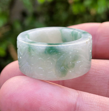 Close-up of continuous flowing swirl patterns and fine-grained texture on an icy imperial green Burmese jade ring
