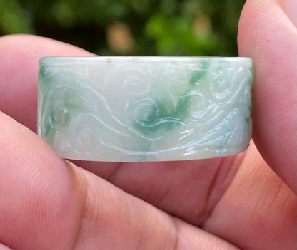 Close-up of continuous flowing swirl patterns and fine-grained texture on an icy imperial green Burmese jade ring