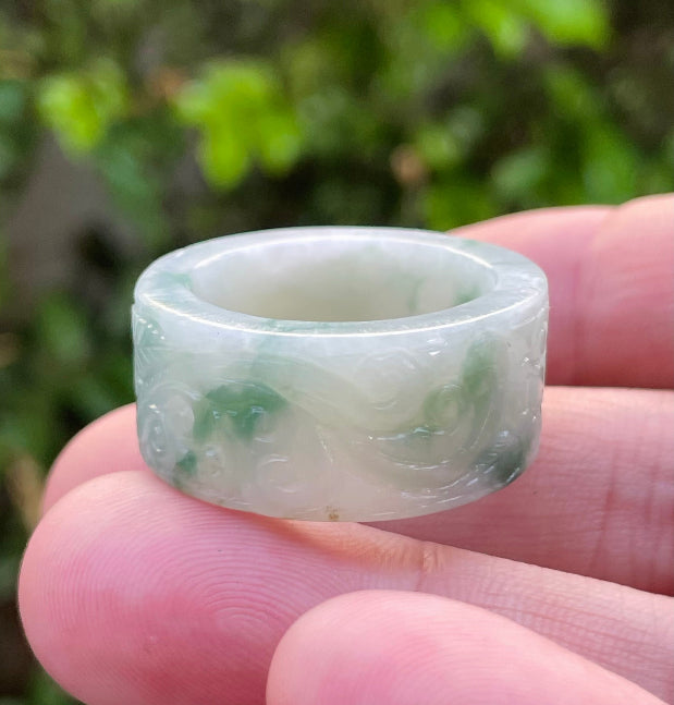 Close-up of continuous flowing swirl patterns and fine-grained texture on an icy imperial green Burmese jade ring