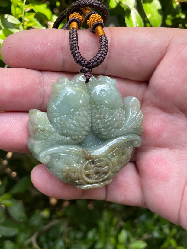 Untreated Type A Burmese jade pendant showing translucent luster with beautiful bluish green colors on an adjustable cord