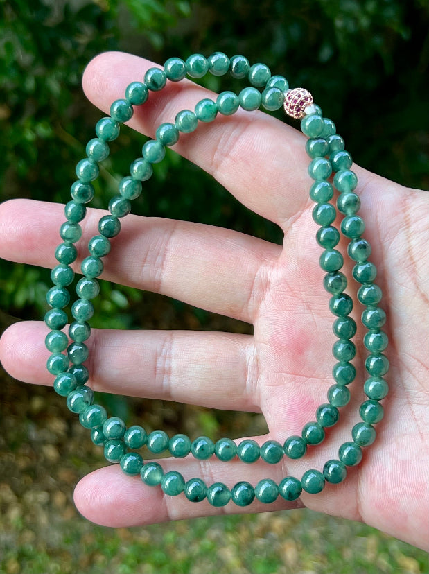 Close-up of 6.2mm Certified Grade A Burmese jadeite beads featuring beautiful icy imperial and apple green hues, item JN074