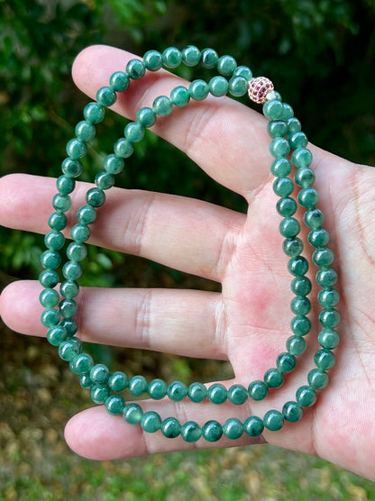 Close-up of 6.2mm Certified Grade A Burmese jadeite beads featuring beautiful icy imperial and apple green hues, item JN074