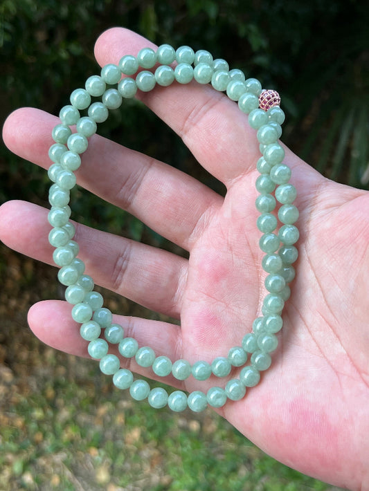 Close-up of 6.7mm Certified Grade A Burmese jadeite beads featuring beautiful icy imperial and apple green hues, item JN079