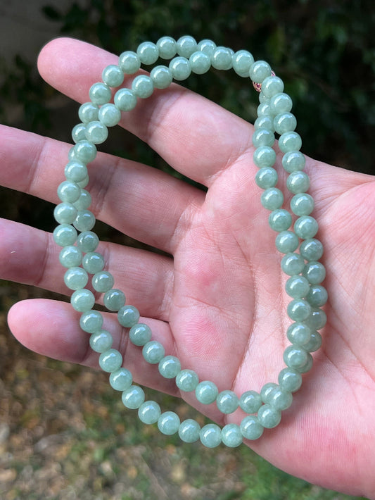 Close-up of 6.7mm Certified Grade A Burmese jadeite beads featuring beautiful icy imperial and apple green hues, item JN080
