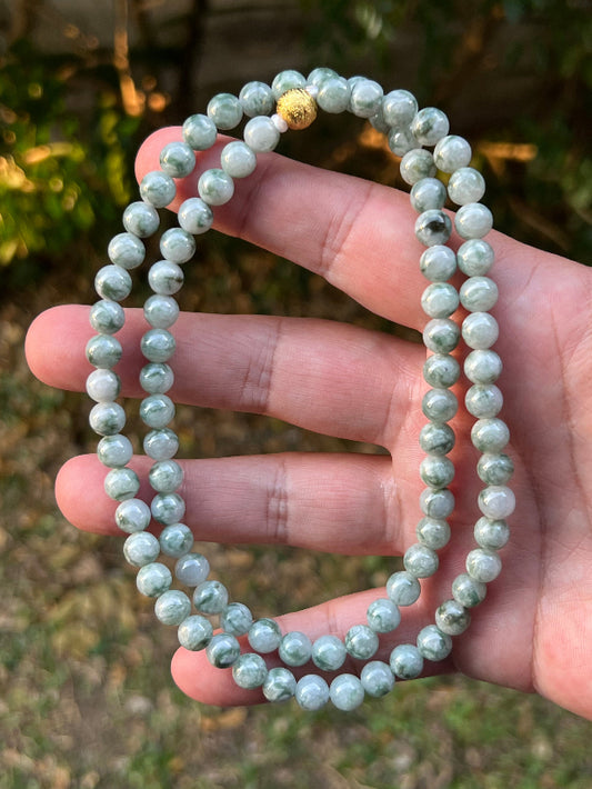 Close-up of 6.9mm Certified Grade A Burmese jadeite beads featuring beautiful icy imperial and apple green hues, item JN094