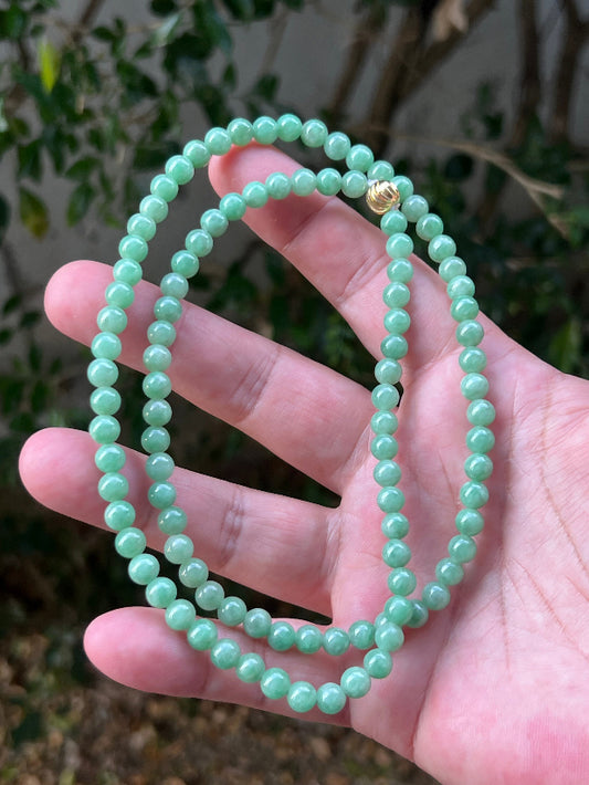 Close-up of 6mm Certified Grade A Burmese jadeite beads featuring beautiful icy imperial and apple green hues, item JN084
