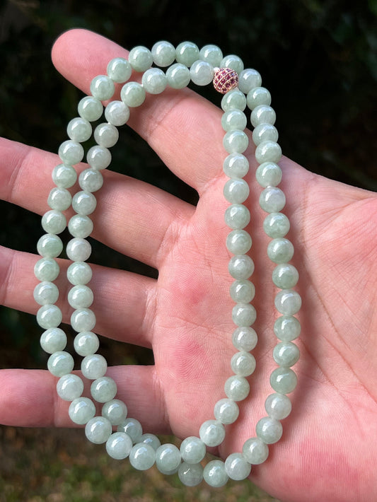 Close-up of 7.3mm Certified Grade A Burmese jadeite beads featuring beautiful icy imperial and apple green hues, item JN082