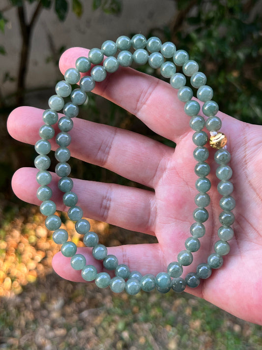 Close-up of 7.3mm Certified Grade A Burmese jadeite beads featuring beautiful icy imperial and apple green hues, item JN089