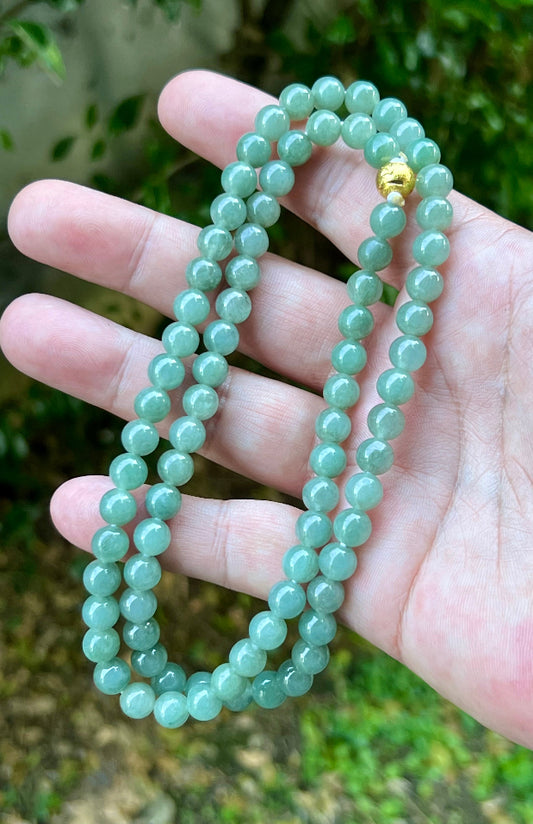 Close-up of 7.5mm Certified Grade A Burmese jadeite beads featuring beautiful icy imperial white and apple green hues, item JN020