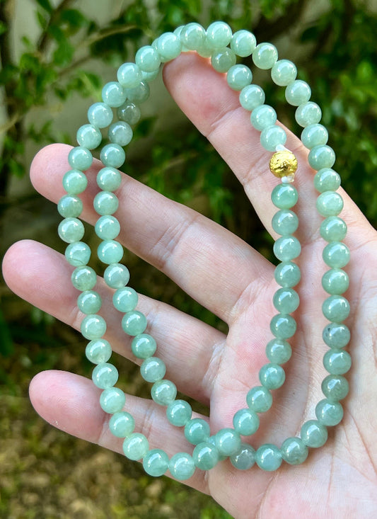 Close-up of 7.5mm Certified Grade A Burmese jadeite beads featuring beautiful icy imperial and apple green hues, item JN022
