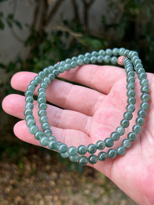 Close-up of 6.4mm Certified Grade A Burmese jadeite beads featuring beautiful icy imperial and deep emerald green hues, item JN092