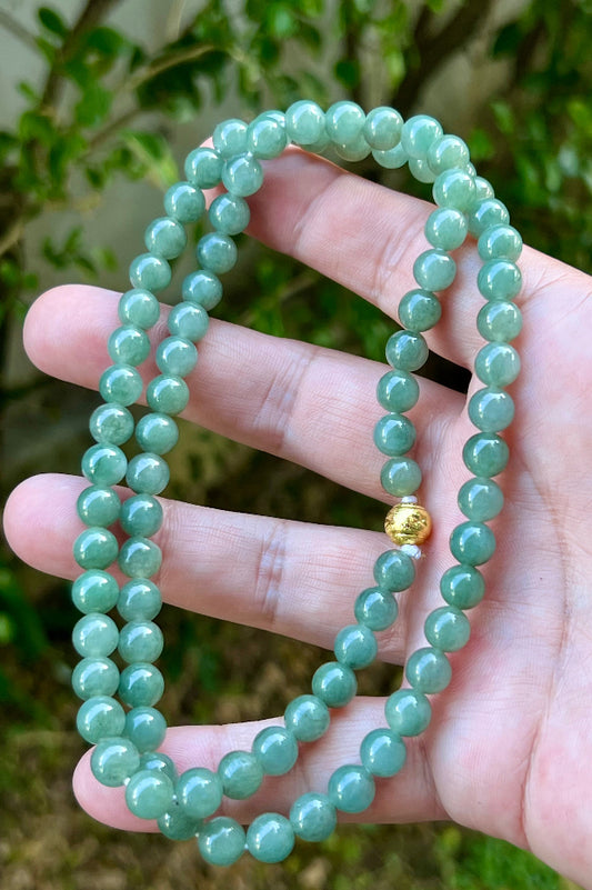 Close-up of 7.5mm Certified Grade A Burmese jadeite beads featuring beautiful icy imperial green and apple green hues, item JN021