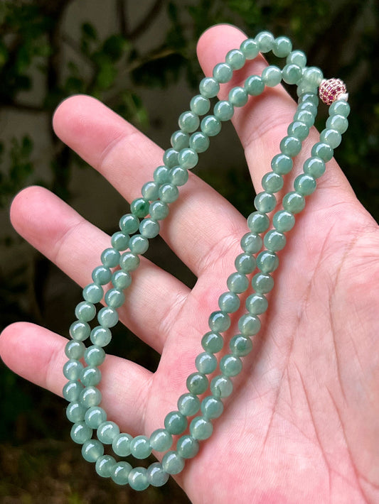 Close-up of 6.2mm Certified Grade A Burmese jadeite beads featuring beautiful icy imperial white and apple green hues, item JN010