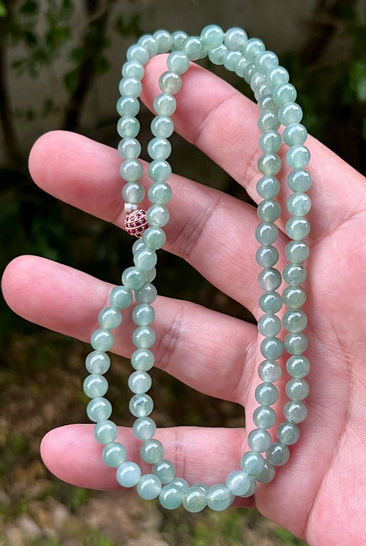Close-up of 6.2mm Certified Grade A Burmese jadeite beads featuring beautiful icy imperial white and apple green hues, item JN011
