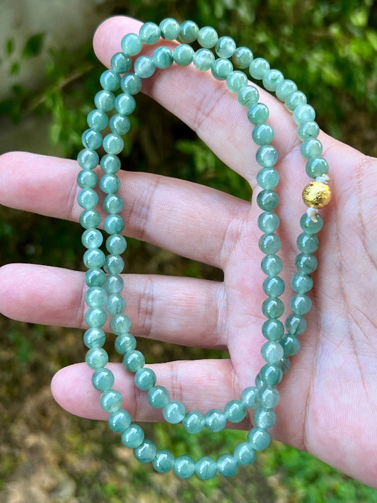 Close-up of 6.4mm Certified Grade A Burmese jadeite beads featuring beautiful icy imperial white and apple green hues, item JN018