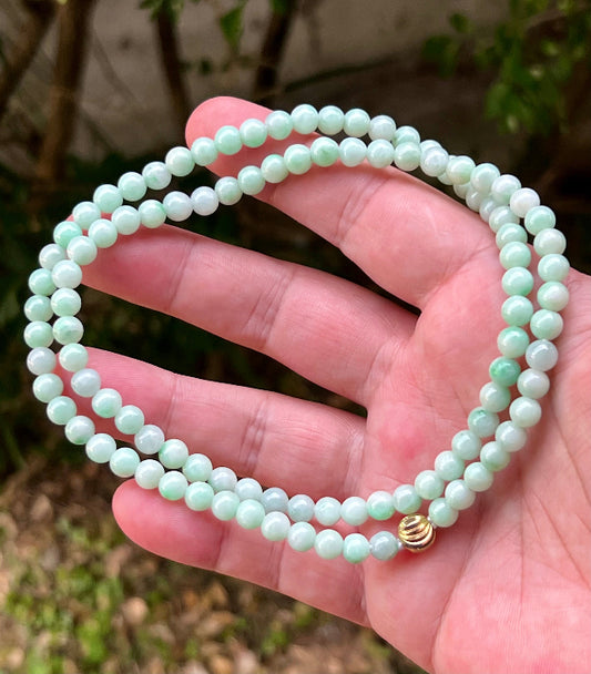 Close-up of 6mm Certified Grade A Burmese jadeite beads featuring beautiful icy imperial white and apple green hues, item JN005