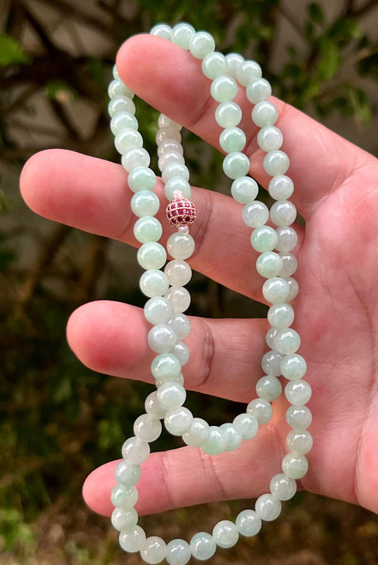 Close-up of 7.1mm Certified Grade A Burmese jadeite beads featuring beautiful icy imperial white and apple green hues, item JN007