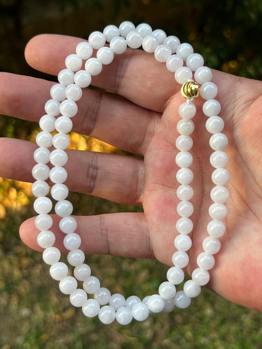 Close-up of 7.2mm Certified Grade A Burmese jadeite beads featuring beautiful icy milky white and light lavender hues, item JN090