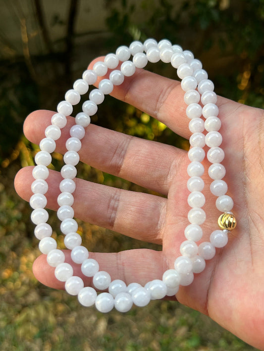 Close-up of 7mm Certified Grade A Burmese jadeite beads featuring beautiful icy milky white and light lavender hues, item JN091