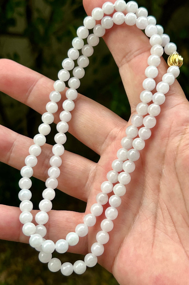 Close-up of 6.2mm Certified Grade A Burmese jadeite beads featuring beautiful icy milky white and light apple green hues, item JN015
