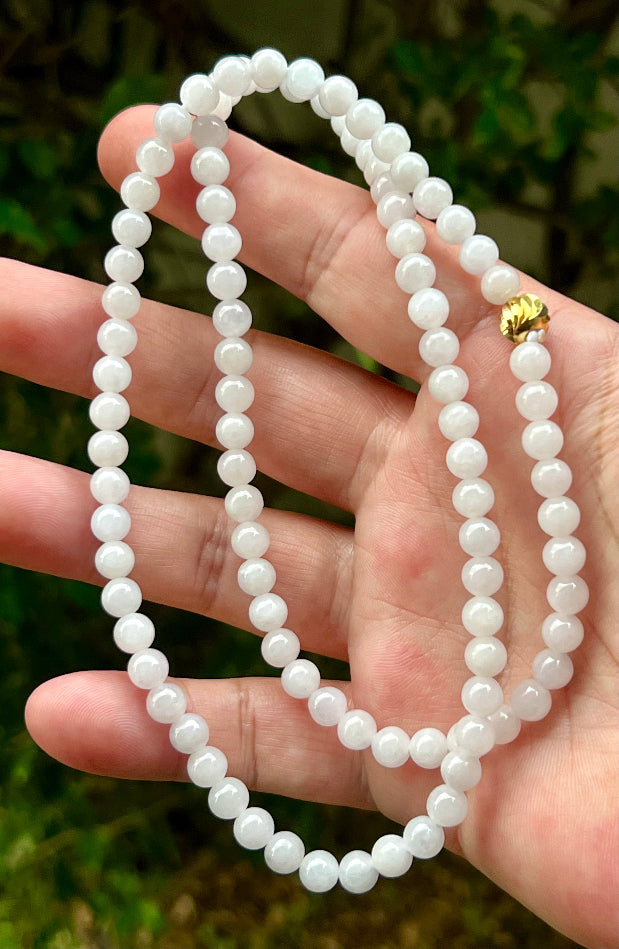 Close-up of 6.4mm Certified Grade A Burmese jadeite beads featuring beautiful icy milky white and light apple green hues, item JN014
