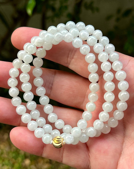 Close-up of 6.8mm Certified Grade A Burmese jadeite beads featuring beautiful icy milky white and light apple green hues, item JN013