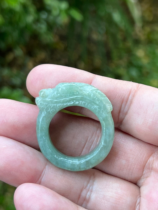 Hand holding a Size US 12.5 certified Grade A Burmese jadeite ring featuring a detailed hand-carved dragon motif in icy green, item JDR006