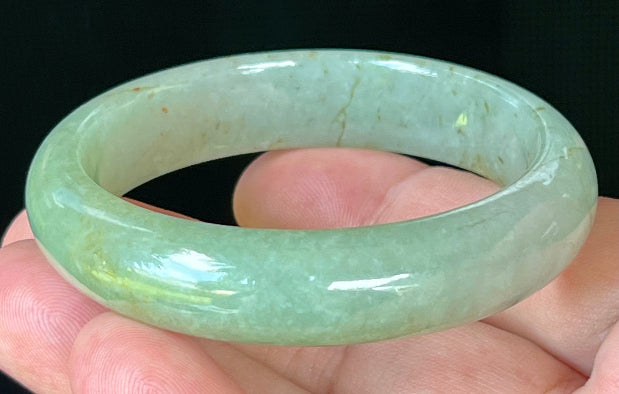 Close-up of fine crystalline texture and honey hues on icy apple green jadeite bangle