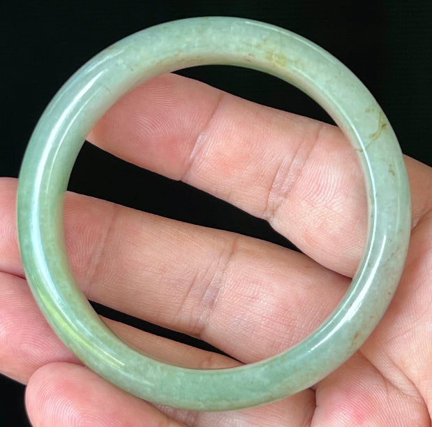 Close-up of fine crystalline texture and honey hues on icy apple green jadeite bangle
