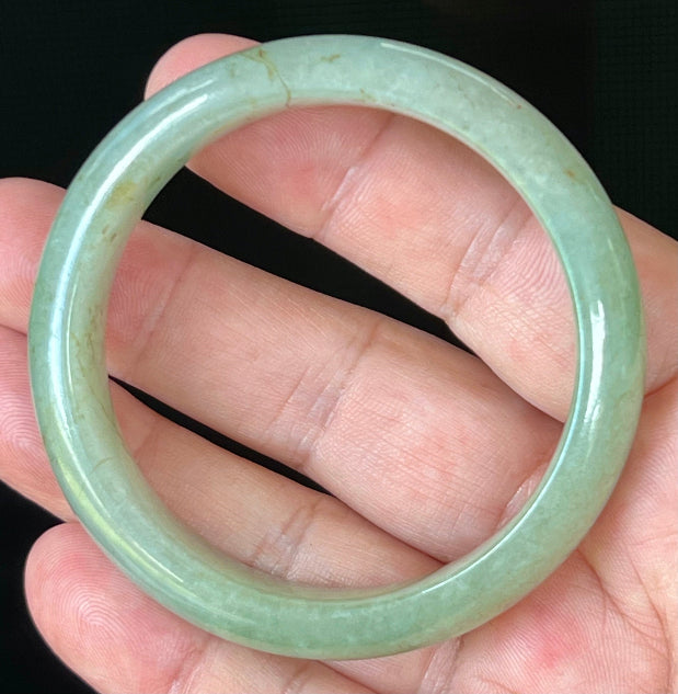 Close-up of fine crystalline texture and honey hues on icy apple green jadeite bangle