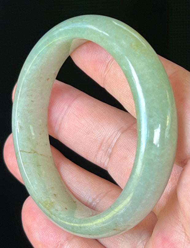 Close-up of fine crystalline texture and honey hues on icy apple green jadeite bangle