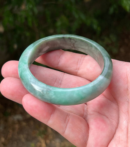 Close-up of moss in snow and blue green patterns on icy green jadeite bangle
