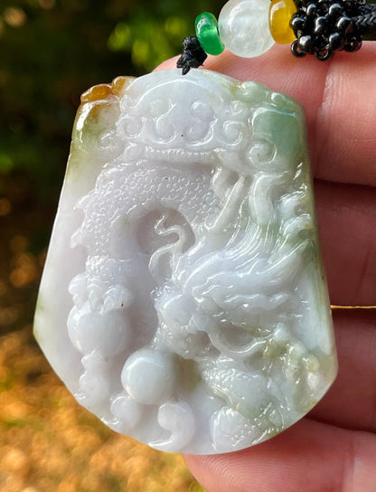 Untreated Type A Burmese jade pendant showing translucent luster with beautiful imperial green, white, and golden brown colors on an adjustable cord