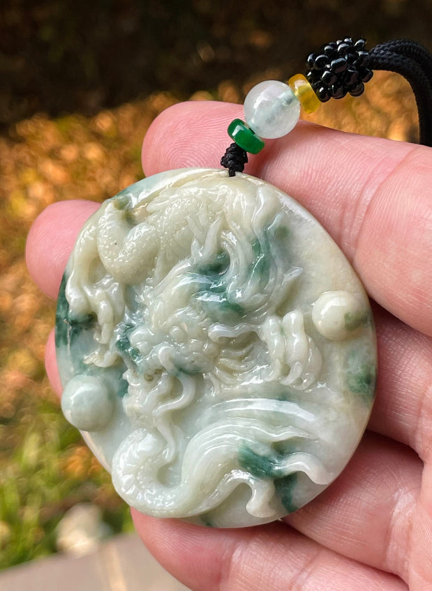 Untreated Type A Burmese jade pendant showing translucent luster with beautiful imperial green and white colors on an adjustable cord