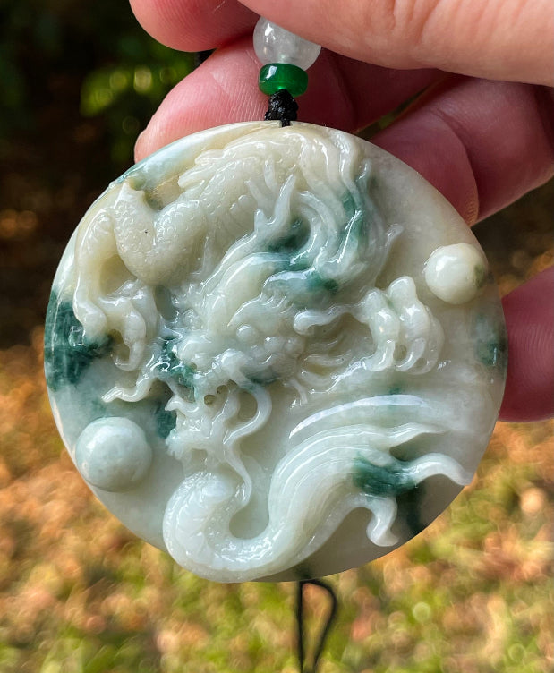 Untreated Type A Burmese jade pendant showing translucent luster with beautiful imperial green and white colors on an adjustable cord